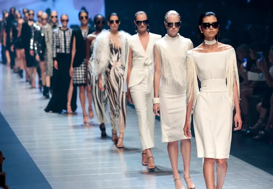 The full cast walks out together at the close of a runway show